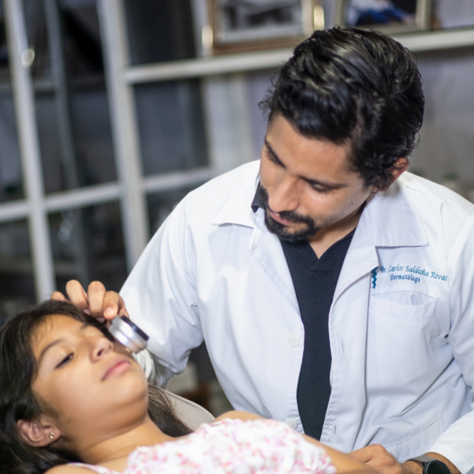 Dr. Saldaña realizando dermatoscopia a una paciente